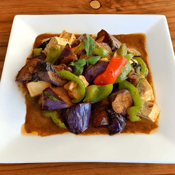 Thai eggplant and tofu stir-fry with green and red bell peppers in a savory sauce.