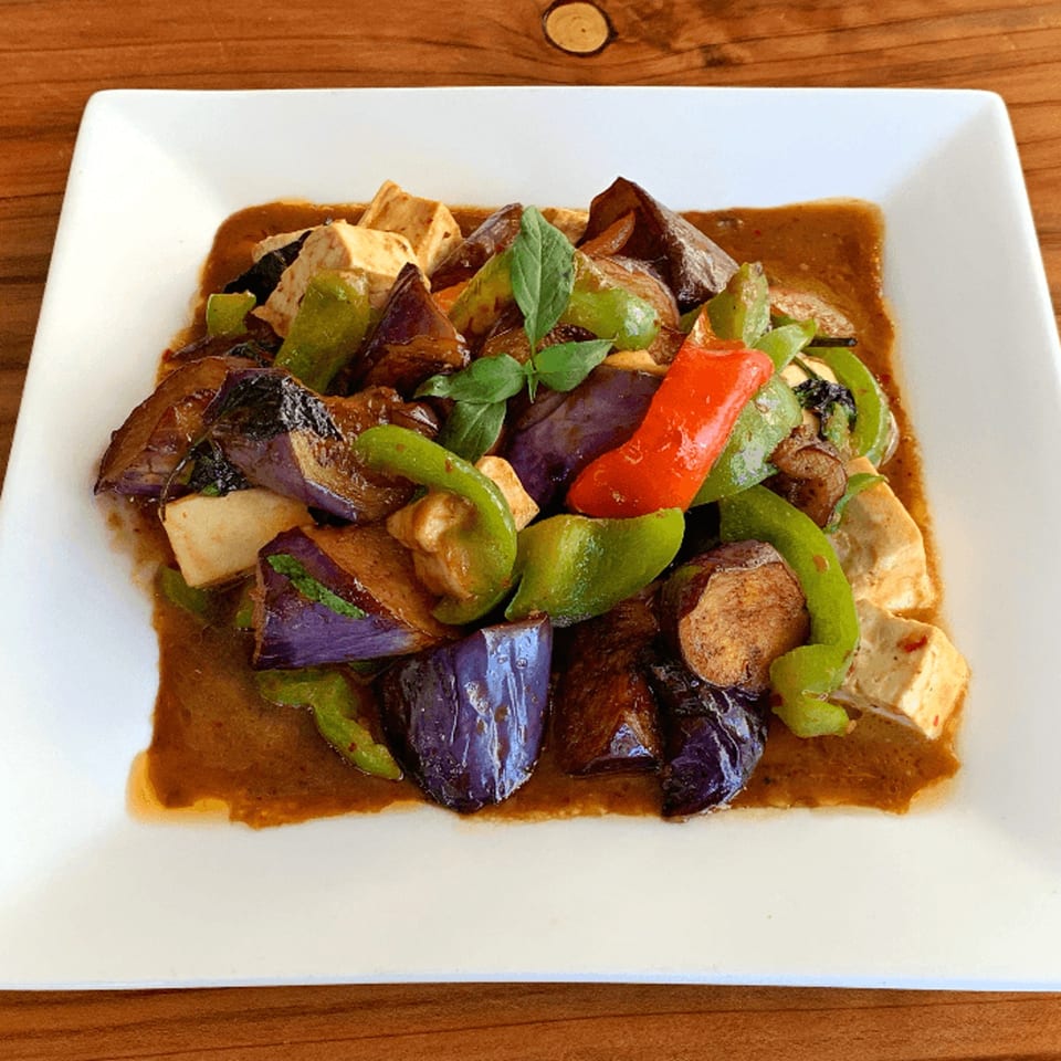 Thai eggplant and tofu stir-fry with green and red bell peppers in a savory sauce.